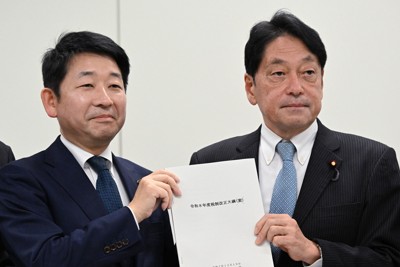 まとまった2026年度税制改正大綱を手に写真撮影に応じる自民党の小野寺五典税調会長（右）と日本維新の会の梅村聡税調会長＝衆院第2議員会館で2025年12月19日午後3時54分、平田明浩撮影