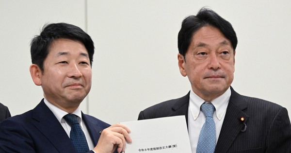 まとまった2026年度税制改正大綱を手に写真撮影に応じる自民党の小野寺五典税調会長（右）と日本維新の会の梅村聡税調会長＝衆院第2議員会館で2025年12月19日午後3時54分、平田明浩撮影
