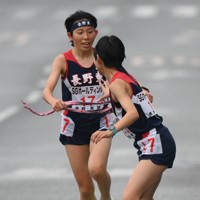 3区、中継所で4区の本田結彩（手前）にたすきを渡す長野東の真柴愛里＝京都市内で2025年12月21日、久保玲撮影