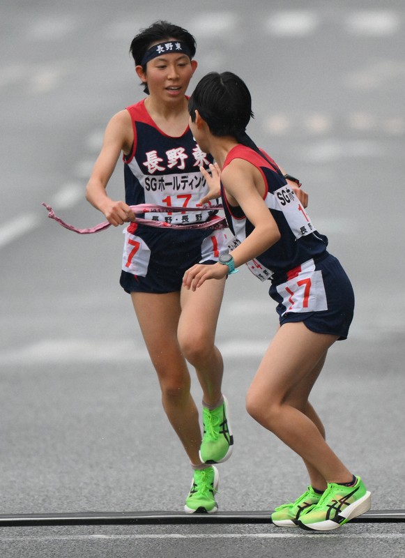 3区、中継所で4区の本田結彩（手前）にたすきを渡す長野東の真柴愛里＝京都市内で2025年12月21日、久保玲撮影