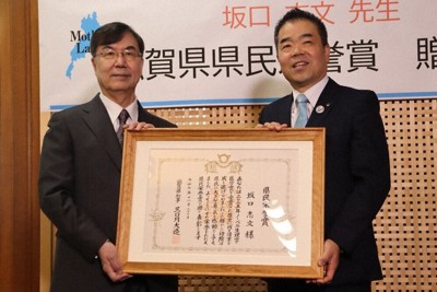 三日月大造知事（右）から県民栄誉賞の賞状を渡された坂口志文さん＝大津市京町4で、菊池真由撮影