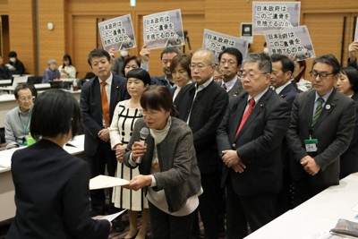 政府の担当者（左）に要請書を手渡す「長生炭鉱の水非常を歴史に刻む会」の井上洋子代表理事（中央）＝衆院第1議員会館で2025年12月23日午後1時21分、後藤由耶撮影