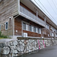 松鶴城跡の石垣の上に建つ椿泊小の校舎。写真に書き込んだ赤い実線に挟まれた付近に、絵図にも描かれた海から館へ出入りする門があったとされる＝徳島県阿南市椿泊町の市立椿泊小で2025年10月26日午後0時1分、植松晃一撮影