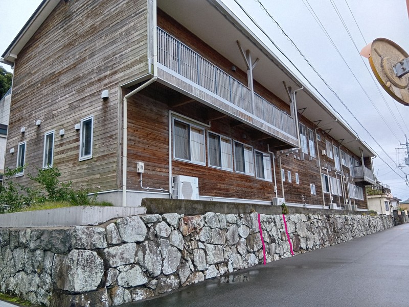 松鶴城跡の石垣の上に建つ椿泊小の校舎。写真に書き込んだ赤い実線に挟まれた付近に、絵図にも描かれた海から館へ出入りする門があったとされる＝徳島県阿南市椿泊町の市立椿泊小で2025年10月26日午後0時1分、植松晃一撮影