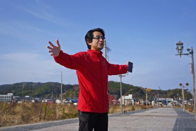 能登半島地震で建物がなくなった朝市通りに立ち、朝市の今後について語る輪島市朝市組合の冨水長毅組合長＝石川県輪島市で2025年12月2日、岩本一希撮影
