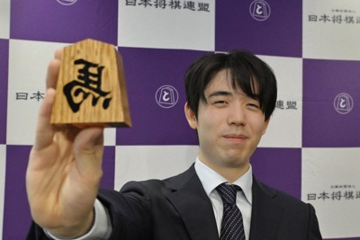 「左馬」の駒を手にポーズをとる藤井聡太名人＝大阪府高槻市で2025年12月5日、北村隆夫撮影