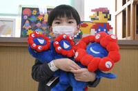 Shion Mizutani hugs dolls of Osaka Expo's mascot Myaku-Myaku, donated by the Baltic Pavilion, in the city of Izumi, Osaka Prefecture, on Dec. 17, 2025. (Mainichi/Tadakazu Nakamura)