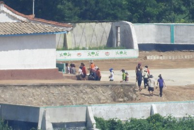北朝鮮の住民たち。何らかの作業に動員されているとみられる＝韓国北西部・金浦市から2025年7月23日午前10時41分、福岡静哉撮影（超望遠カメラを使用）