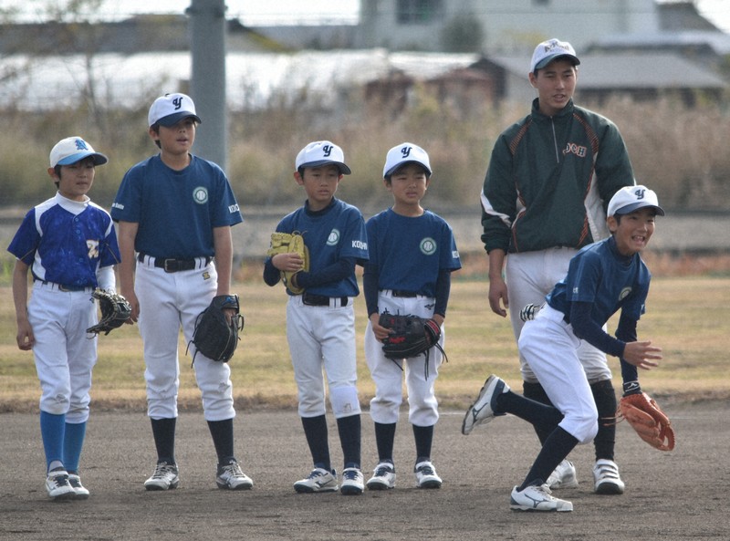 高知農の野球部員と一緒にノックを受ける少年野球チームの児童たち＝高知県南国市の高知農業高校グラウンドで2025年12月20日午前10時37分、行方一男撮影