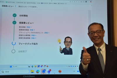 KDDIが開発した本部長AI「A－BOSS」の分析画面の前で、自身の似顔絵と同じポーズを取る那谷雅敏執行役員常務＝東京都港区のKDDI本社で2025年11月5日午後1時57分、町野幸撮影