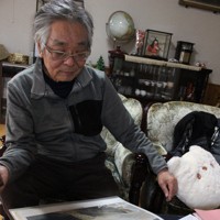 造成当時の作東メガソーラー敷地の航空写真を見る岩崎清治さん＝岡山県美作市で2025年11月8日午後3時7分、石川勝己撮影