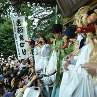 巡行を終え、参拝者に餅をまく天狗＝茨城県笠間市で12月21日午後3時18分、高橋昌紀撮影