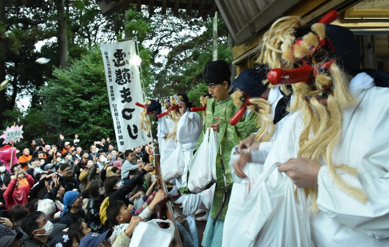 巡行を終え、参拝者に餅をまく天狗＝茨城県笠間市で12月21日午後3時18分、高橋昌紀撮影
