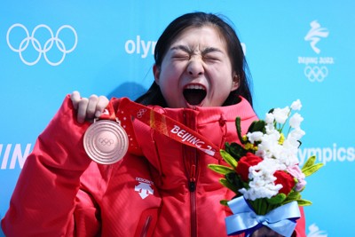 メダルセレモニーを終え、銅メダルを手に満面の笑顔を見せる坂本花織＝北京・メダルプラザで2022年2月18日、貝塚太一撮影