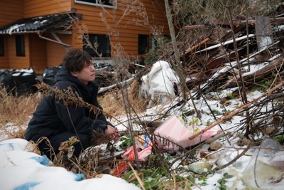 能登半島地震から2年を迎え、妻と子ども3人の一家4人を亡くした家があった場所を見つめる大間圭介さん＝石川県珠洲市で2026年1月1日午前9時39分、中川祐一撮影