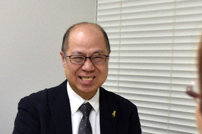 手話通訳士と手話でやり取りする田門浩さん＝東京都新宿区で