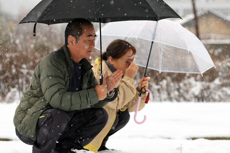 地震で母と兄を亡くし、自宅跡で手を合わせる舩本悦司さん（左）と妻淳子さん＝石川県珠洲市で2026年1月1日、滝川大貴撮影