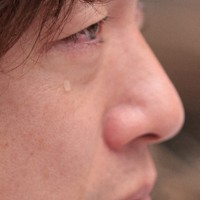 現場で花を供え、家族を思い涙を流す大間圭介さん＝石川県珠洲市で2026年1月1日、中川祐一撮影