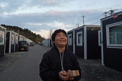 拍子木を手に仮設住宅を回る宇都宮孝弘さん＝石川県珠洲市で2025年12月28日午後4時35分、岩本一希撮影