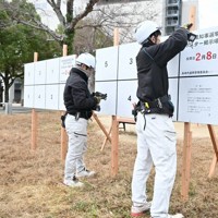 ポスター掲示板を設置する委託業者＝長崎市宝町で2026年1月9日午前9時32分、百田梨花撮影