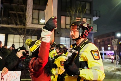 米移民・税関捜査局（ICE）捜査官による女性射殺事件を受けた抗議デモで、捜査当局と対峙（たいじ）するデモ参加者（左）＝米中西部ミネソタ州ミネアポリスで2026年1月9日、AP