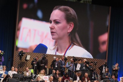 ロシアのプーチン大統領の年末記者会見で質問する、親露派組織「もう一つのウクライナ」所属の女性（画面内）＝モスクワで2025年12月19日、真野森作撮影