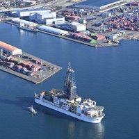 静岡市清水区の清水港を出港する地球深部探査船「ちきゅう」＝2026年1月12日午前9時3分、本社ヘリから