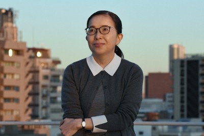夕日を浴びながらポーズをとるエッセイストの酒井順子さん＝東京都新宿区で2025年12月16日、宮本明登撮影