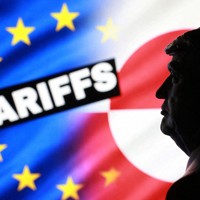 3Dプリンターで作られたトランプ米大統領のミニチュア。背後に、欧州連合（EU）やグリーンランドの旗と「関税」という文字が見える＝17日、ロイター