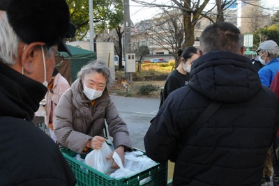 無料の弁当を配布する「あじいる」のメンバーら＝東京都台東区の隅田公園山谷堀広場で2026年1月18日午後3時3分、木村敦彦撮影
