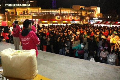 交流イベントの抽選会に参加するふるさと納税寄付者と市民。左手前に景品の羽毛布団などが並ぶ＝山梨県富士吉田市新西原5の富士急ハイランドで2025年10月25日午後5時48分、野田樹撮影
