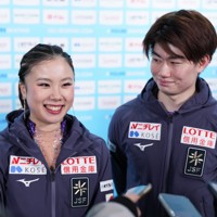 公式練習を終え、記者の取材に笑顔で答える吉田唄菜、森田真沙也組＝中国・北京の国家体育館で2026年1月21日、吉田航太撮影