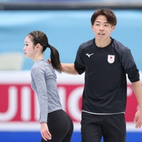 曲かけ練習を終え、長岡柚奈（左）の肩を優しく「ポンポン」とたたく森口澄士＝中国・北京の国家体育館で2026年1月21日、吉田航太撮影
