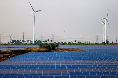 インド南部トゥティコリンにある太陽光発電所。太陽光パネルが敷き詰められた先には風力発電施設も設置されている（Bloomberg）