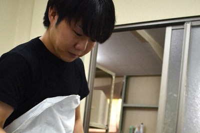 作業中の山口大貴さん。専用器具で成形機の出口を熱し、びんつけ油が出やすいよう滑りをよくしている