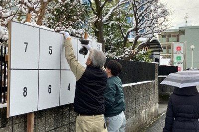 雪が降る中、衆院選の選挙ポスター掲示板の設置作業が急ピッチで進められていた＝愛知県江南市で2026年1月23日、川瀬慎一朗撮影