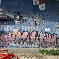 パナマ侵攻で最も被害が大きかったチョリージョ地区。通りの壁には、米軍のヘリコプターやパナマ国旗の絵とともに「忘れない！　許さない！」と書かれている＝パナマ市で2026年1月19日、松井聡撮影