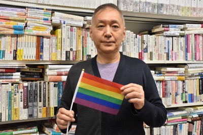 性の多様性を象徴するレインボーフラッグを持つ河口和也さん＝広島市安佐南区の広島修道大学で2025年12月24日午前11時35分、川原聖史撮影