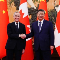 中国の習近平国家主席（右）との会談で握手を交わすカナダのカーニー首相＝北京で2026年1月16日、AP
