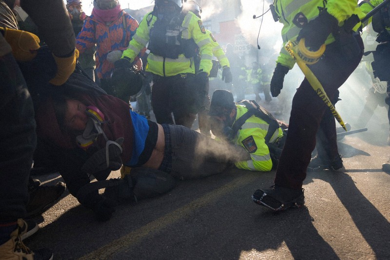 米連邦当局の不法移民取り締まりをめぐり、もみ合う抗議参加者と法執行官ら＝中西部ミネソタ州ミネアポリスで2026年1月24日、AP