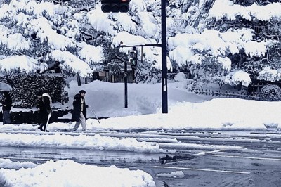 雪が積もった市内中心部を歩く観光客ら＝金沢市内で、阿部弘賢撮影