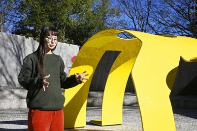 黄色いアーチの前で話す、中村キース・ヘリング美術館主任学芸員の田中今子さん＝山梨県北杜市で