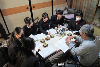 ウラン残土問題で活動した元高校教諭に話を聞く鳥取敬愛高社会部の生徒たち＝鳥取県三朝町で、同校提供