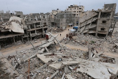 イスラエル軍の攻撃で破壊された建物のがれきに囲まれながら、歩くパレスチナの人＝パレスチナ自治区ガザ地区南部ハンユニスで2026年1月22日、ロイター