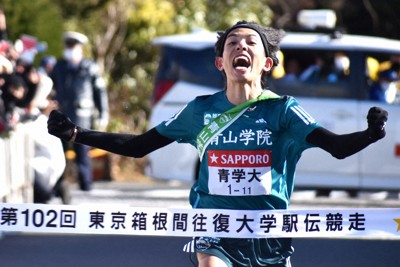 箱根駅伝の往路優勝を果たし、両拳を握り締めてフィニッシュテープを切る青学大の黒田朝日選手＝神奈川県箱根町で2026年1月2日、牧野大輔撮影
