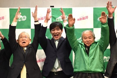 当選が確実となり、支援者らとバンザイをして喜びを表す石田嵩人氏（中央）＝福井市で2026年1月25日午後11時12分、島袋太輔撮影