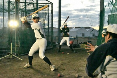 簡易照明の中でティー打撃をする高知農の選手たち。奥のビニールハウスでは生徒たちが野菜を栽培している＝高知県南国市で2025年12月、石川裕士撮影