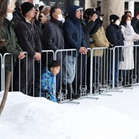 積雪の中で陣営の第一声を聞く有権者ら＝青森県弘前市で2026年1月27日午前9時35分、後藤由耶撮影