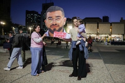 最後に遺体が収容されたイスラエルの男性警察官の写真を持つ女性たち＝イスラエル中部テルアビブで2026年1月26日、ロイター
