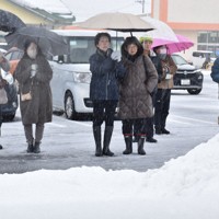 突然強まった雪の中、傘を差して候補者の演説に耳を傾ける有権者ら＝新潟市西蒲区で2026年1月27日、戸田紗友莉撮影